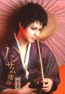 松村龍之介/バストアップ・衣装紫・右手腹・左手番傘・背景オレンジ/舞台「ハンサム落語 第九幕」ブロマイドA
