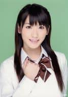 小原春香/バストアップ・衣装白茶色・リボン・右手グー・背景緑/公式生写真