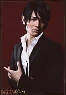 篠谷聖/バストアップ・スーツ黒・シャツ白・背景茶色・右手指揮棒・目線正面・背景茶舞台「RAGTIME S＆D」/公式生写真